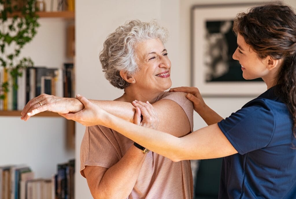 Ältere Frau mit Physiotherapeutin beim Training zu Hause